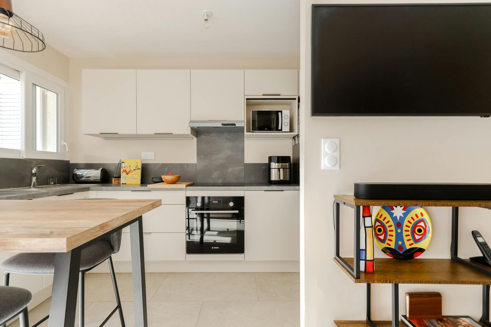 Jasna nowoczesna kuchnia z gładkimi szafkami i dekoracyjnym talerzem