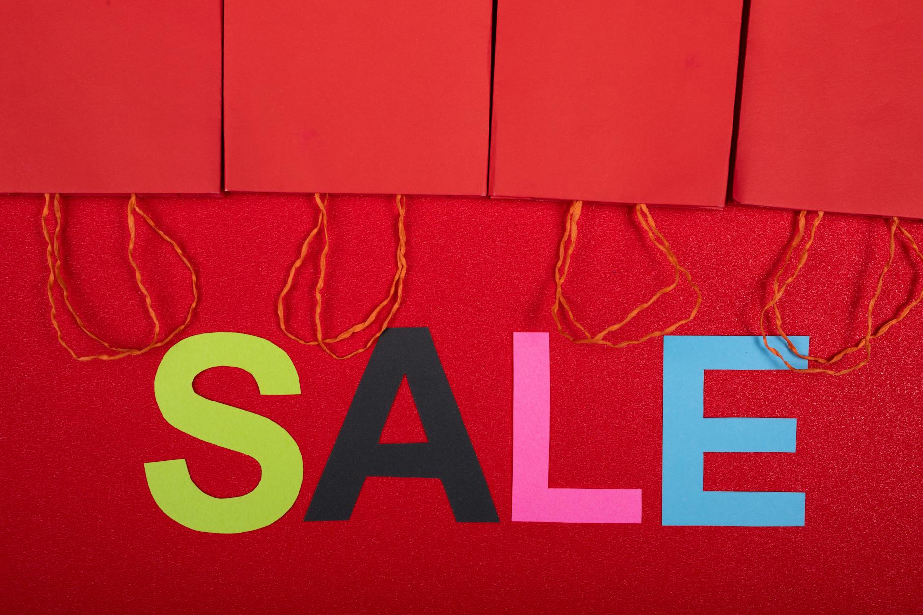 Kolorowy napis sale i czerwone torby zakupowe zachęcające do promocji