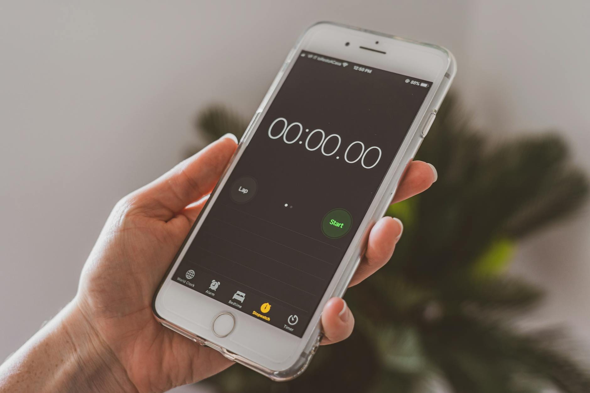 Dłoń trzymająca smartfon z włączonym stoperem odliczającym czas