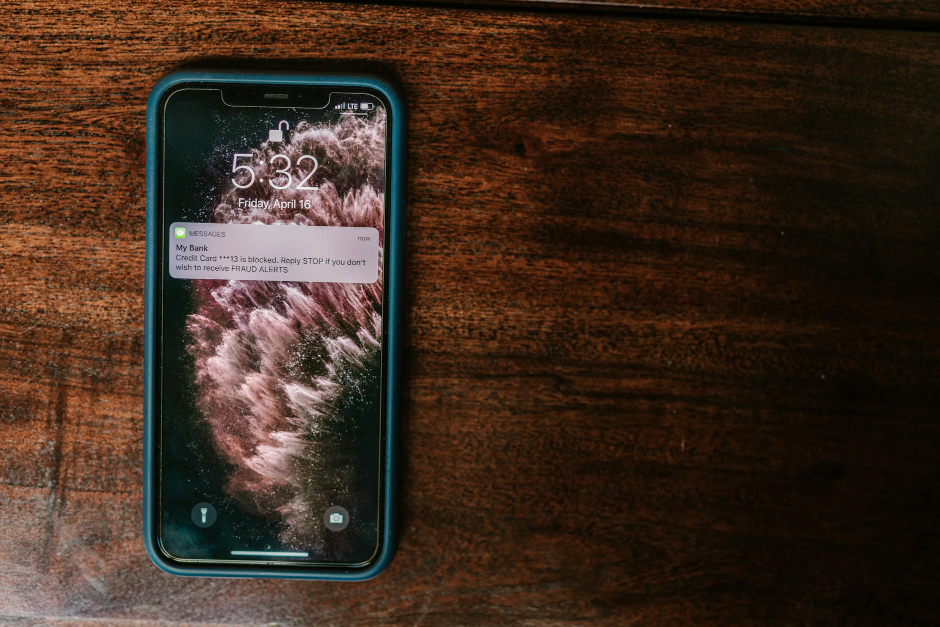 Smartfon na drewnianym stole z powiadomieniem z banku na ekranie